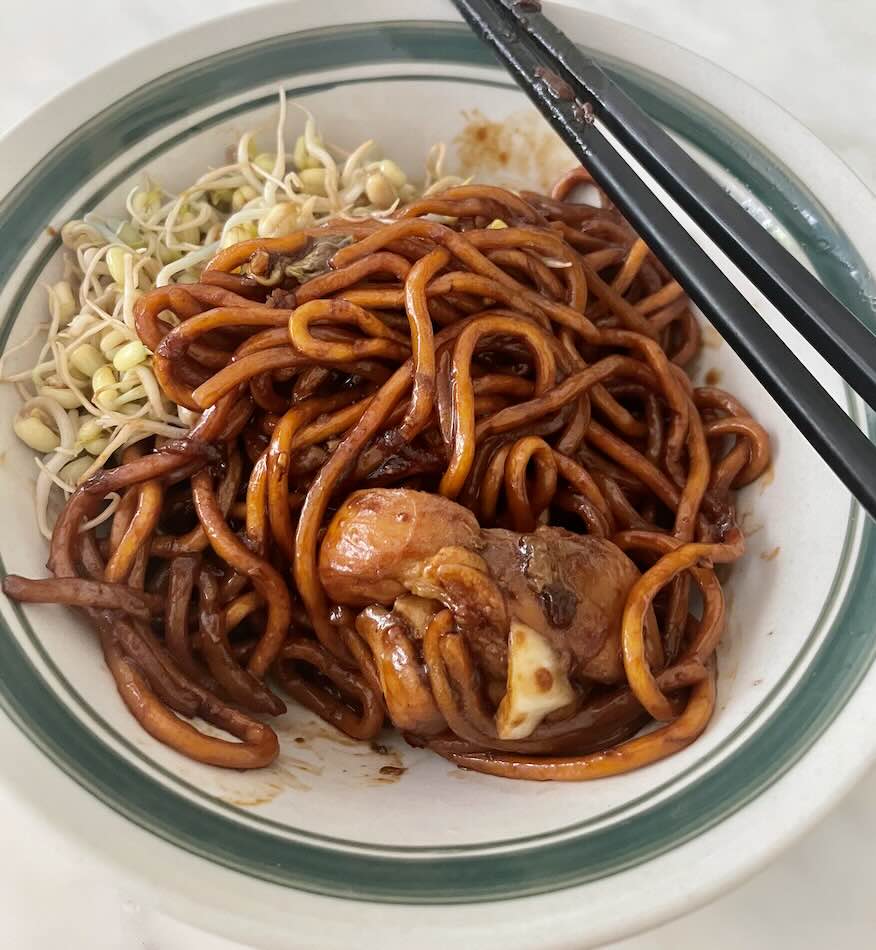 Black mee served with bean sprouts