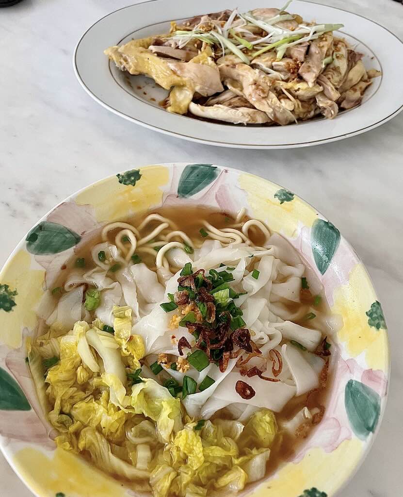 Kway Teow soup in clear broth served with chicken on the side