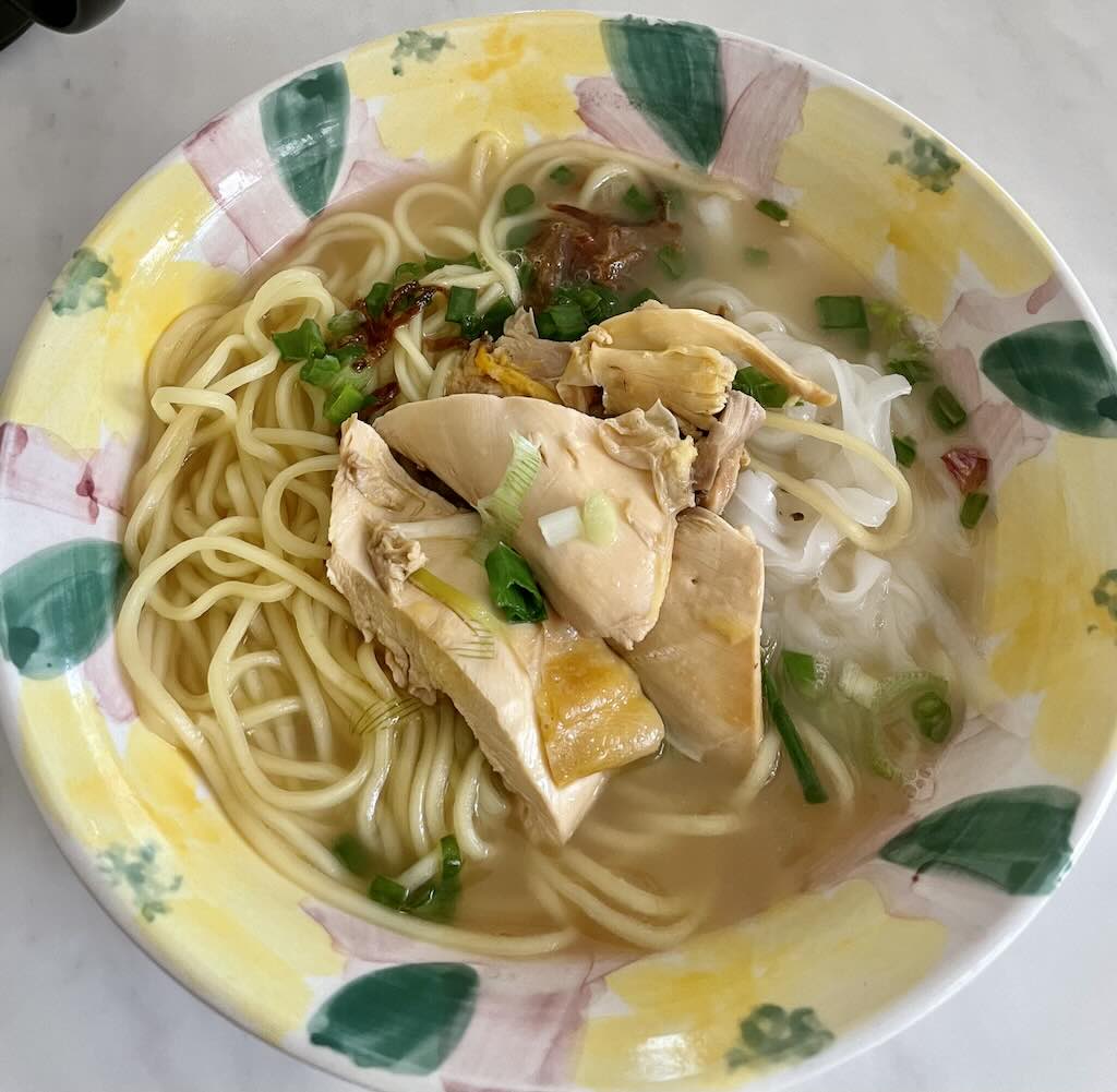 Noodles soup in clear broth served with chicken