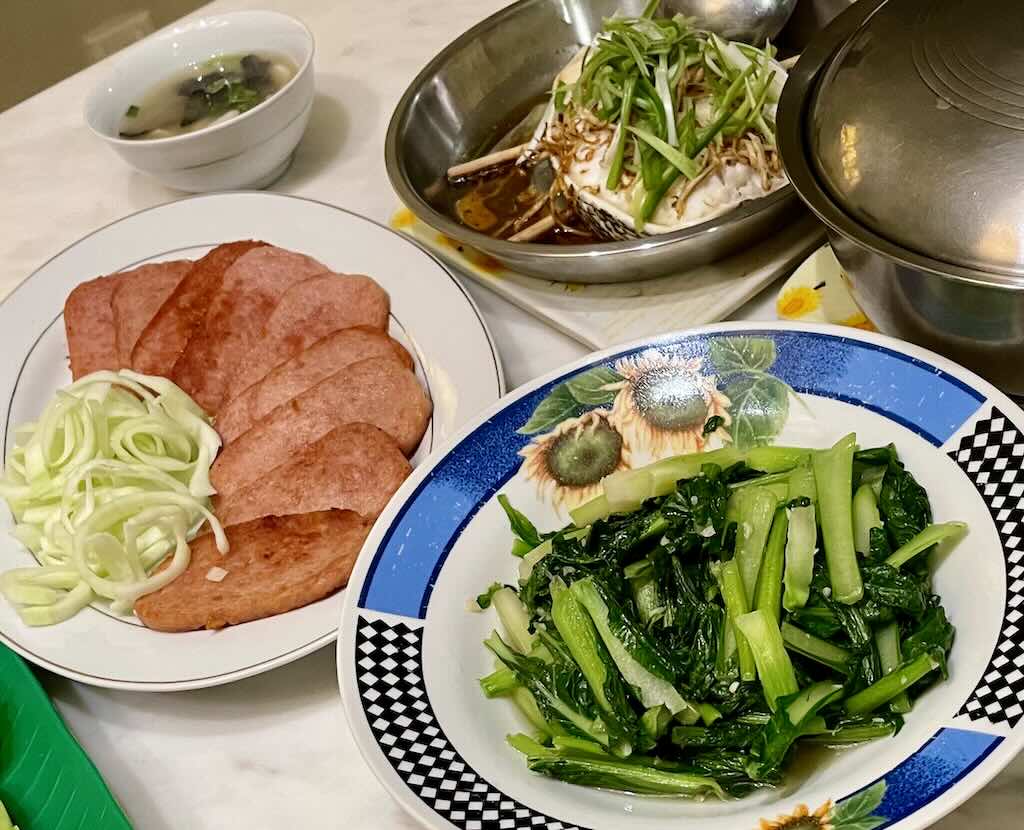 Steamed codfish served with vegetables,luncheon meat